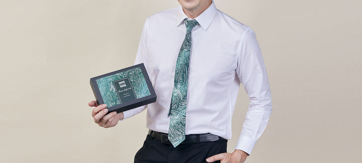 man modeling a green batik necktie and batik pocket square gift set for corporate gifting