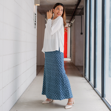 in a lifestyle photo, a model is posing in a batik skirt in the pattern navy lemang