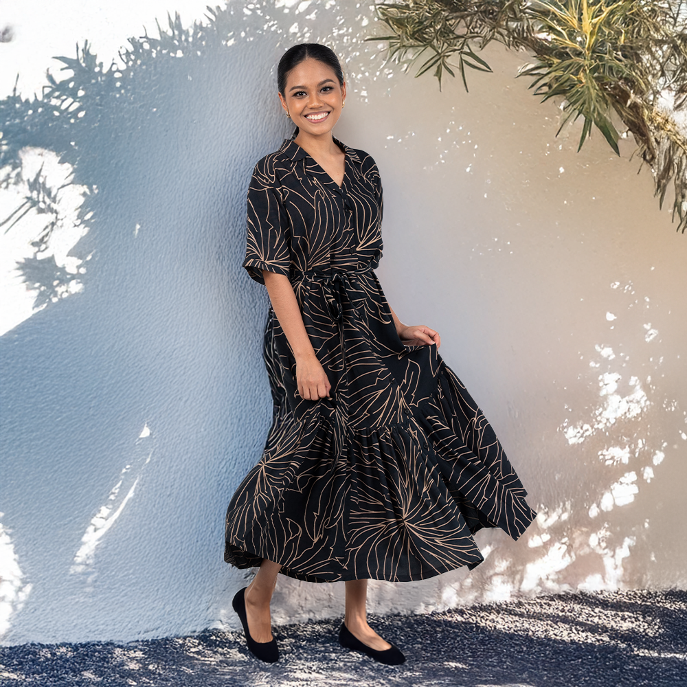 Woman wearing Batik Boutique’s Onyx Palma Button-Up Dress, inspired by Southeast Asian flora, styled outdoors in a flowy silhouette.