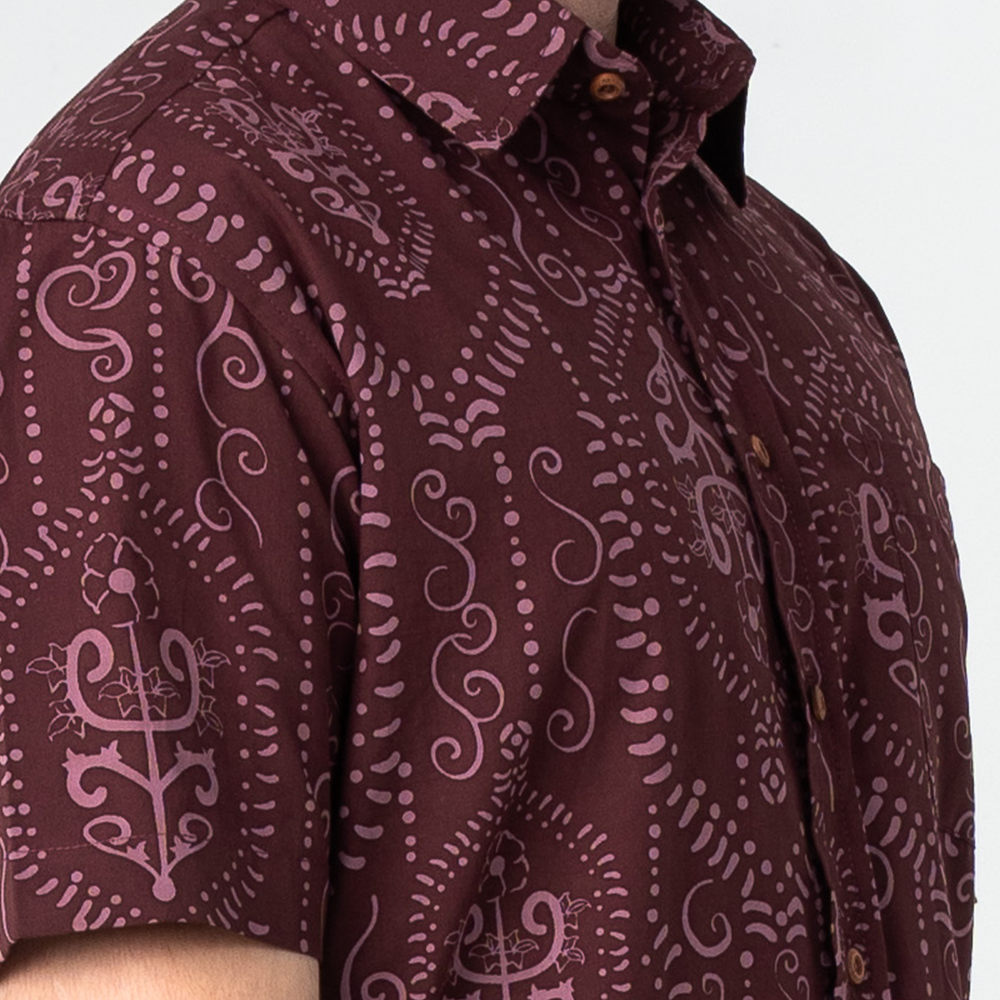 Closeup of Garnet Petola batik shirt sleeve showing intricate luffa flower-inspired Malaysian batik pattern and fabric texture