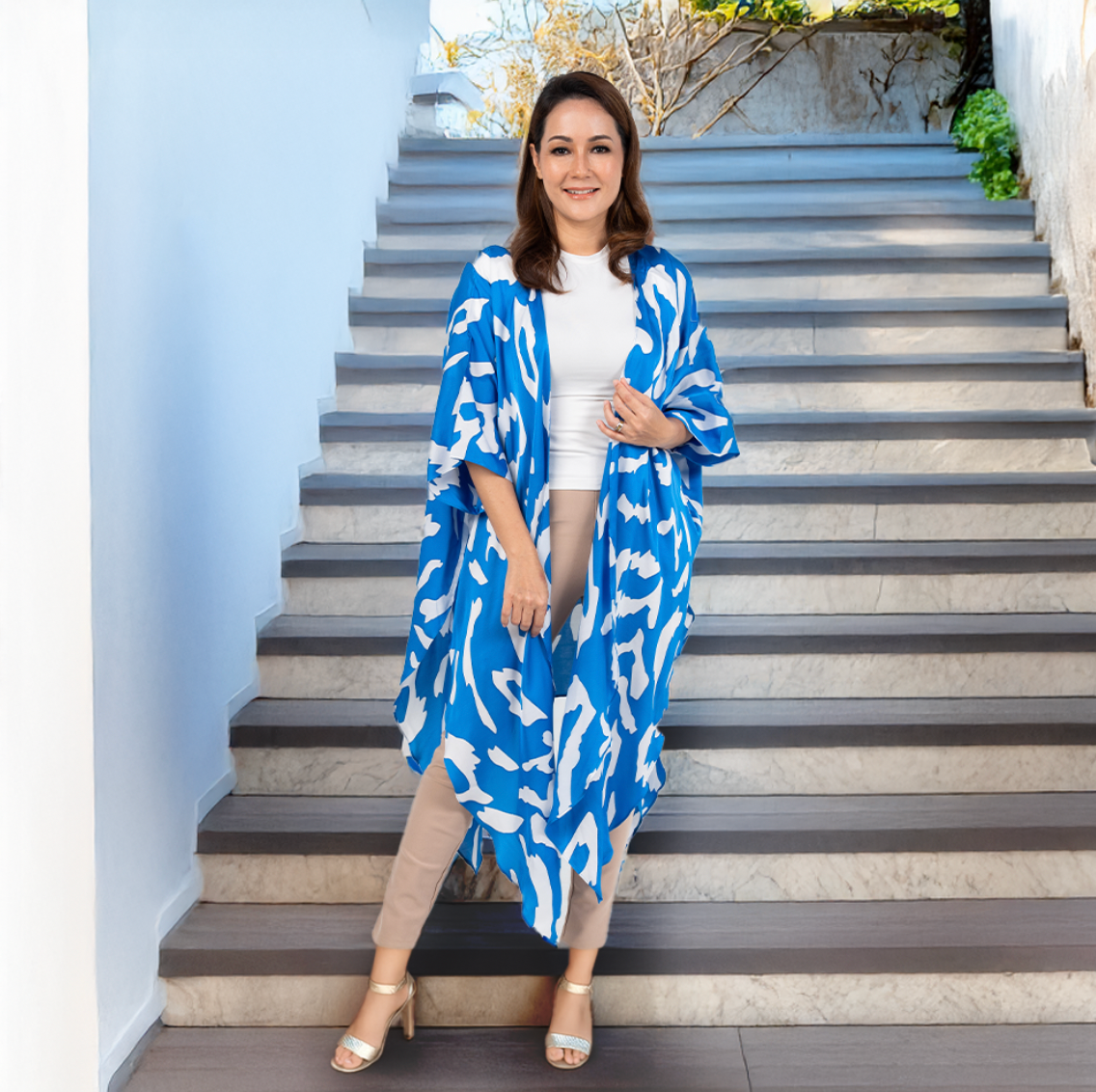 Woman wearing a blue patterned kimono standing on outdoor stairs.
