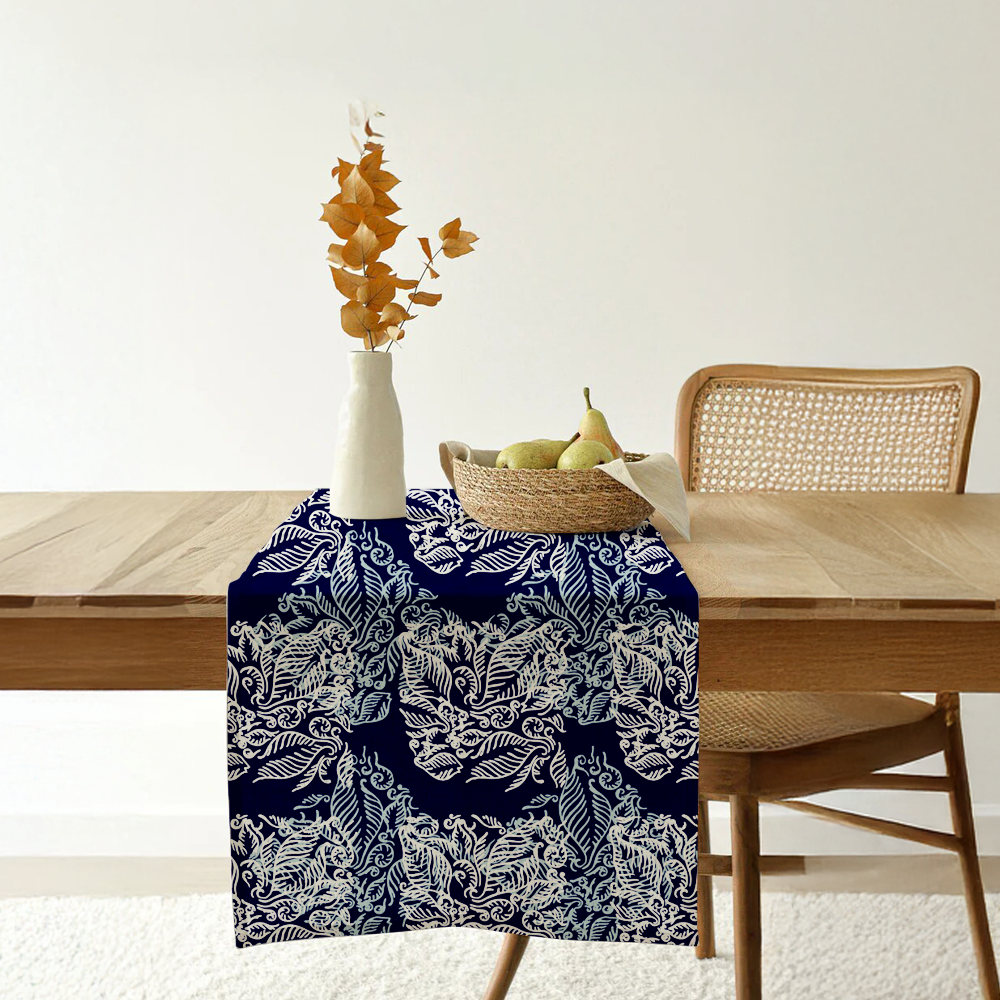 Blue batik table runner with nautical fern motif displayed on a wooden dining table.