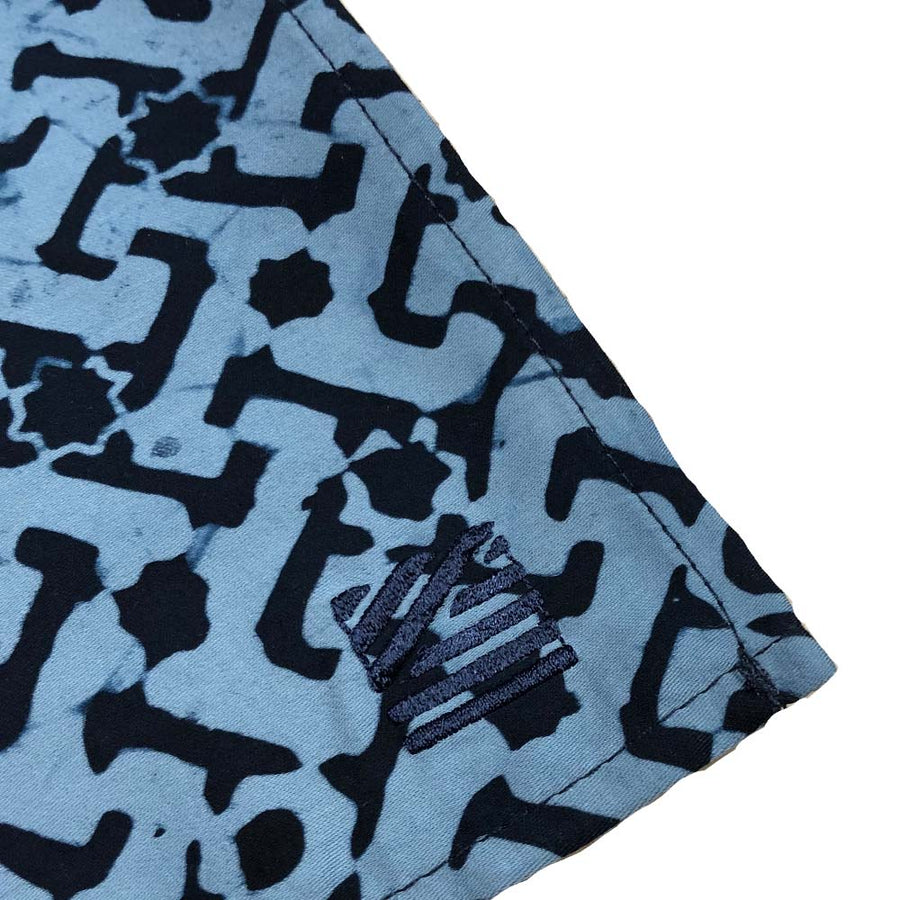 closeup of batik pocket square in the pattern midnight arabesque against a white background