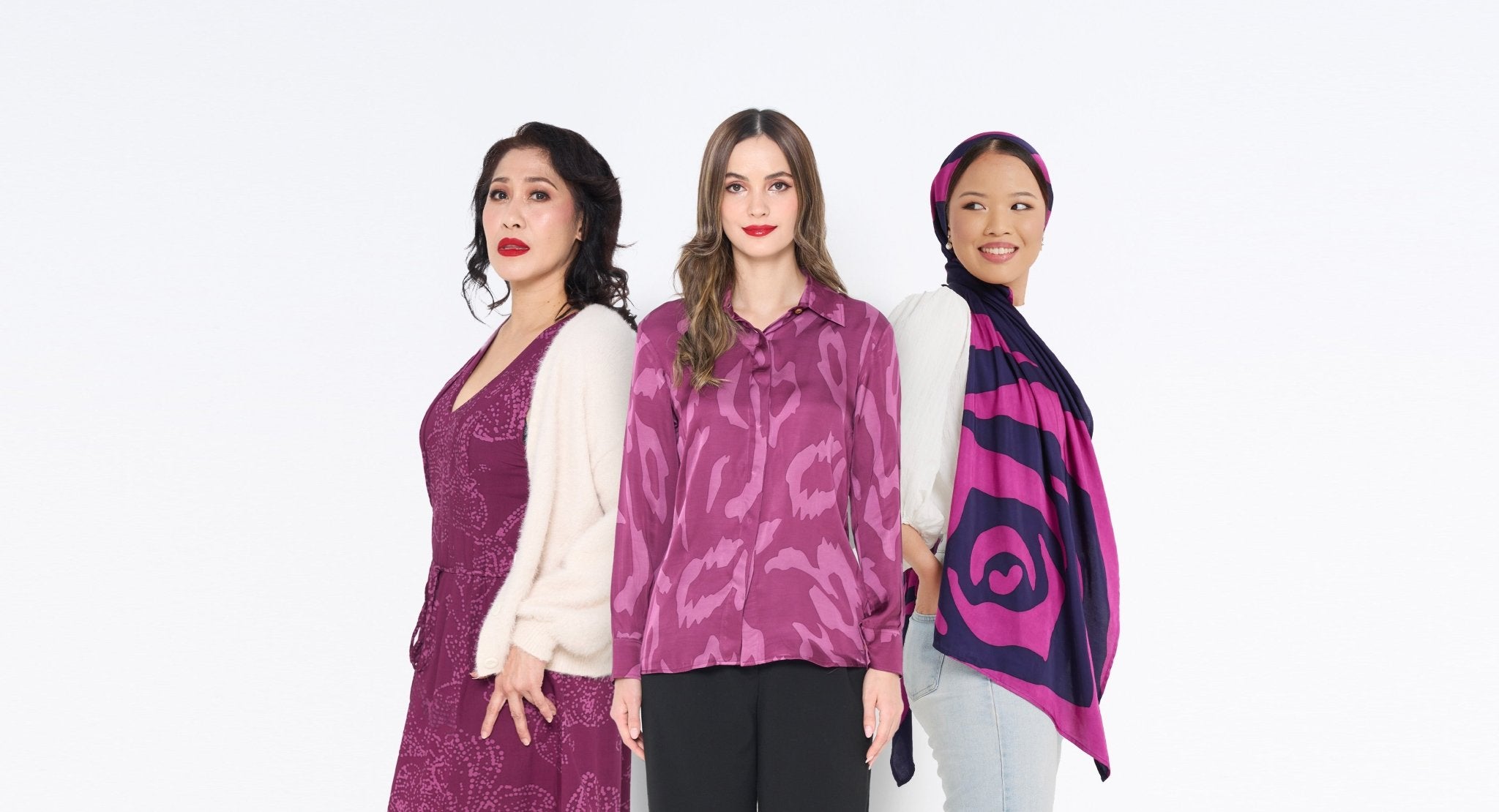 Three women showcasing Batik Boutique’s Plum Orchid Maxi Dress, Plum Rimba Long Sleeve Shirt, and Fuchsia Rose Scarf. Handcrafted batik fashion blending tradition and modern elegance.