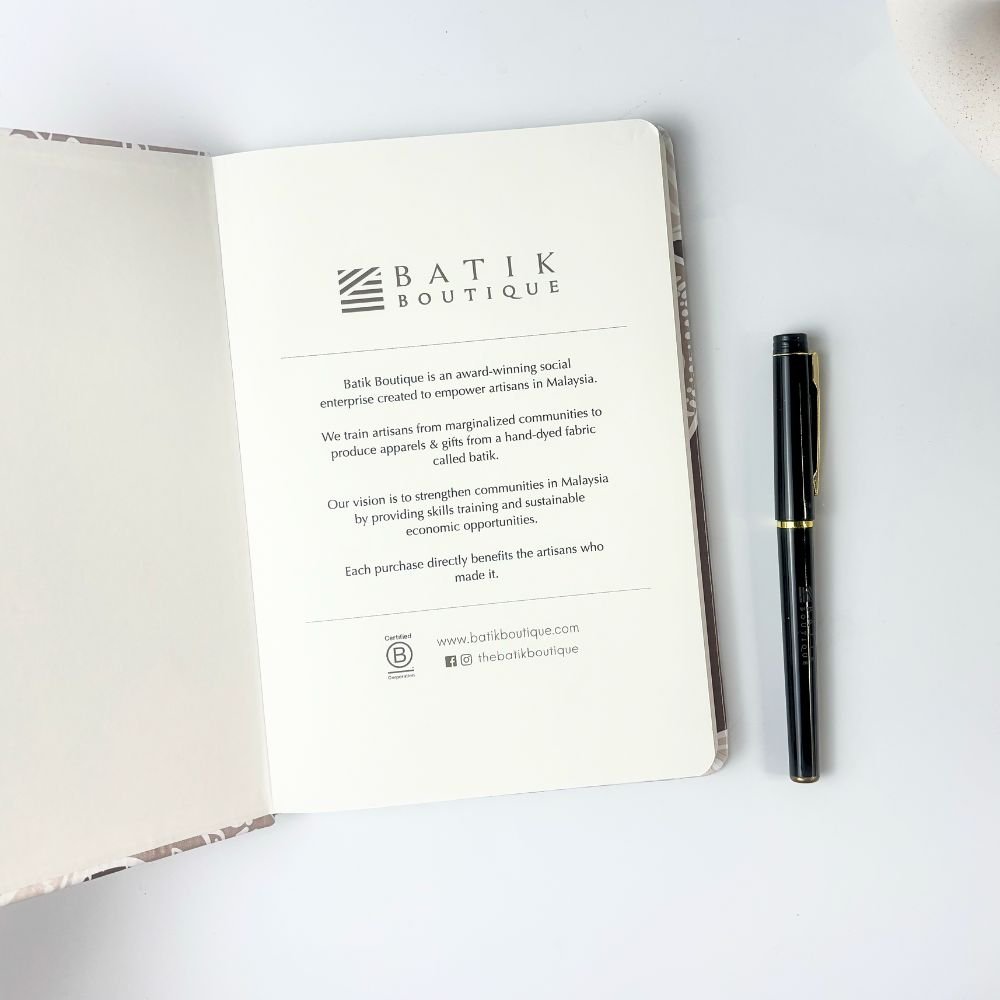 Red hibiscus notebook with pen open to show the first page 