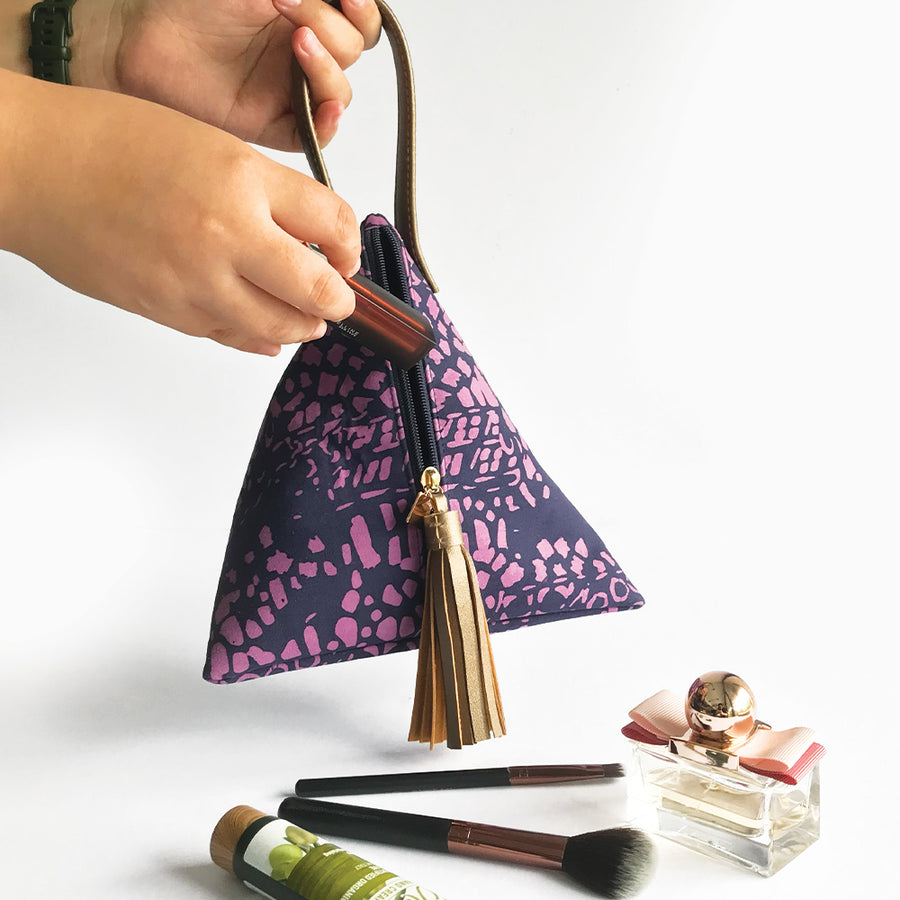 a lifestyle photo of a ketupat bag in the pattern purple bintik against a neutral background