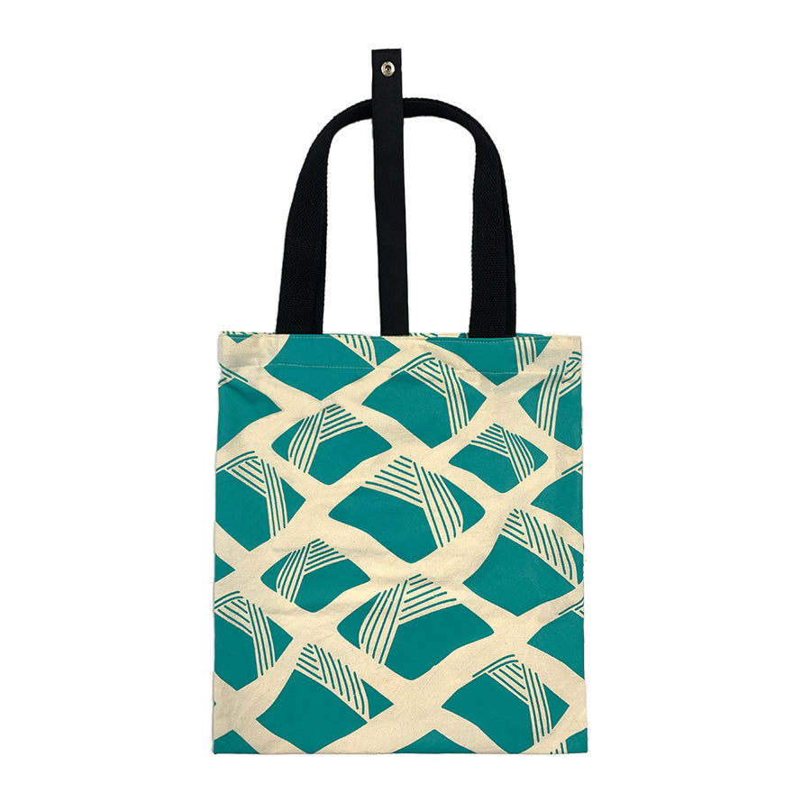 A batik totebag or even a shopping bag with pattern inspired from Nasi Lemak in turquiose color and put on a white background. This photo show the back side of the bag
