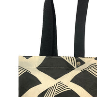 close up of a batik tote bag in front of a white background in nasi lemak motif in the color black