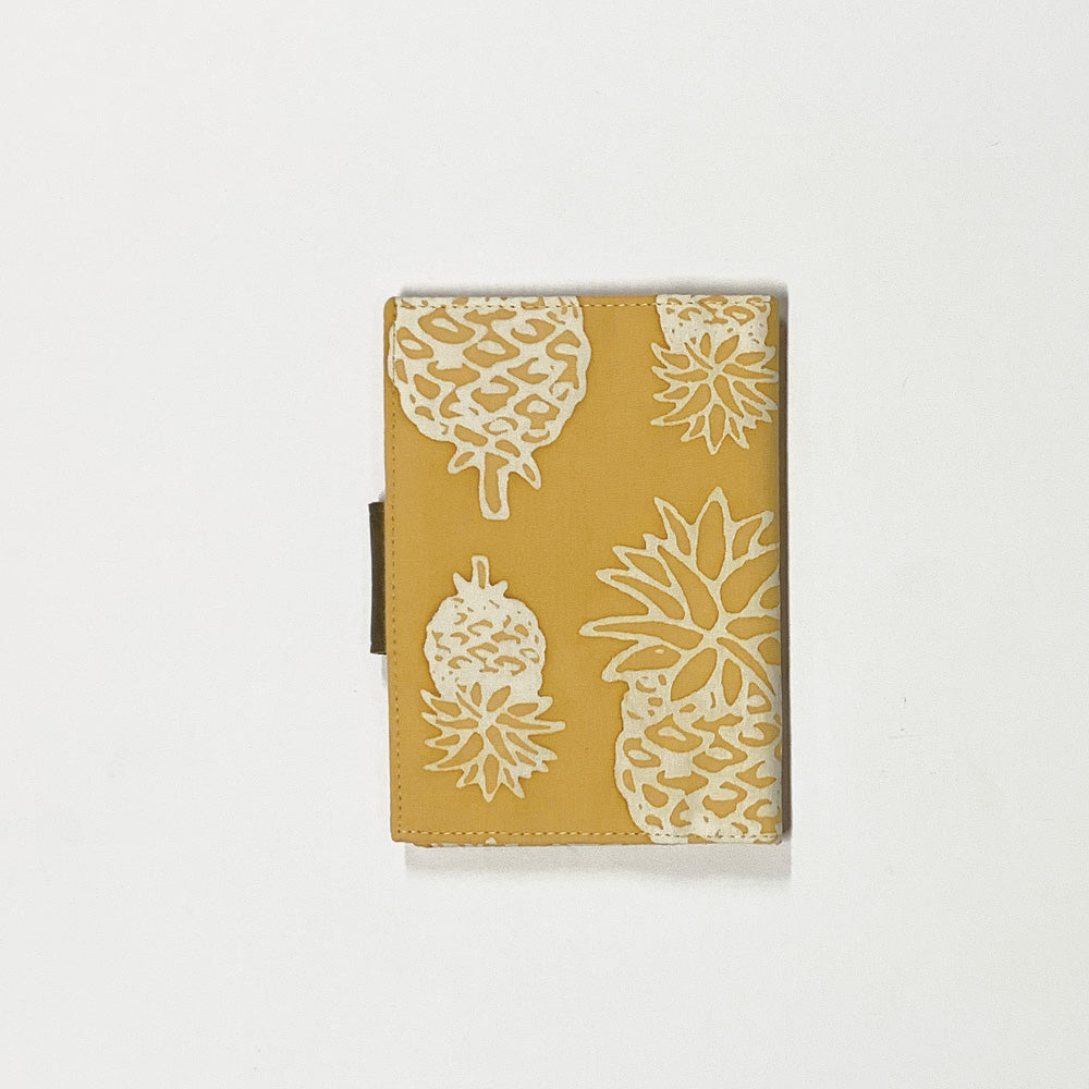 a photo of a passport cover made of batik in the pattern golden pineapple made of batik