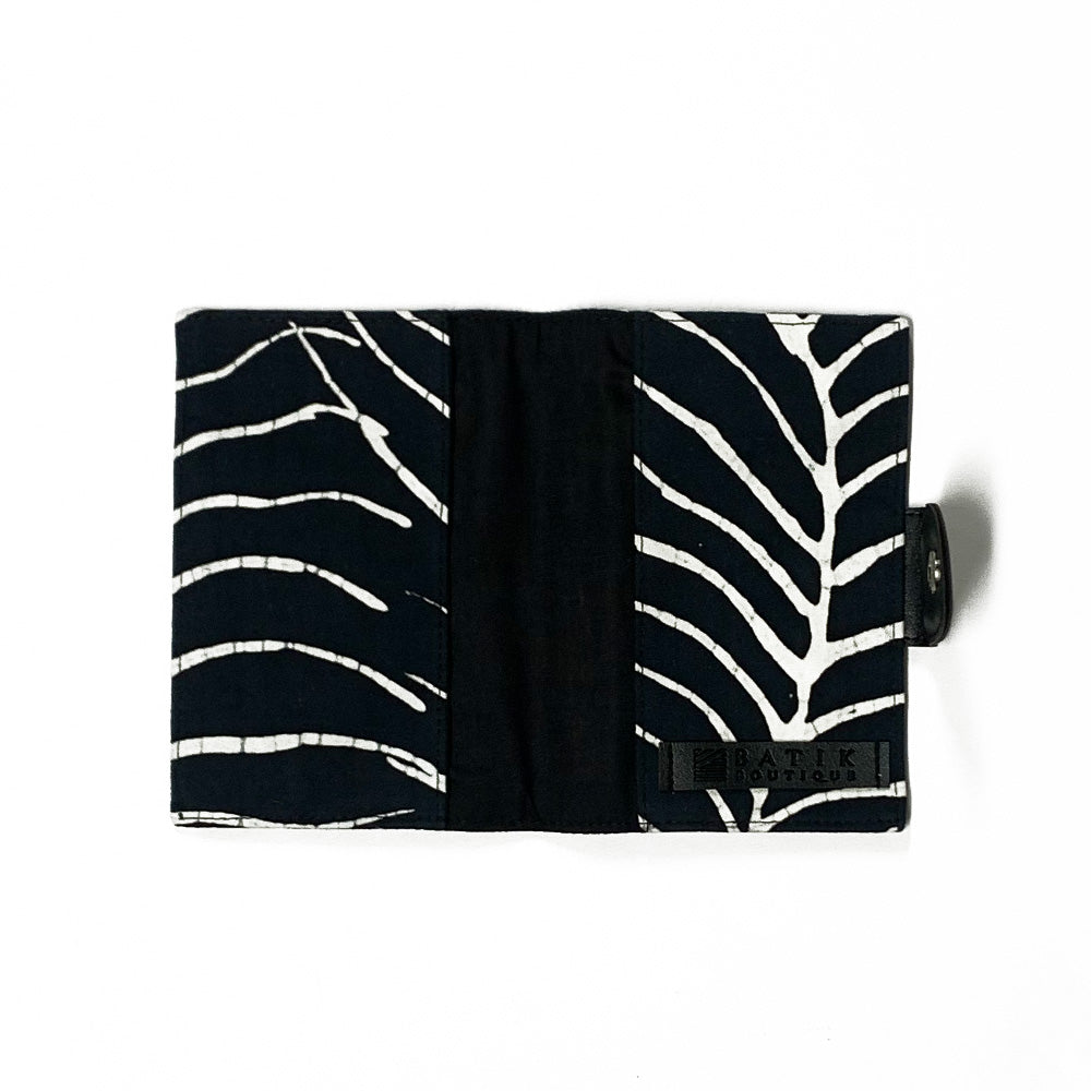 A whitebox photo of passport cover in black fern pattern showing inside of the passport cover