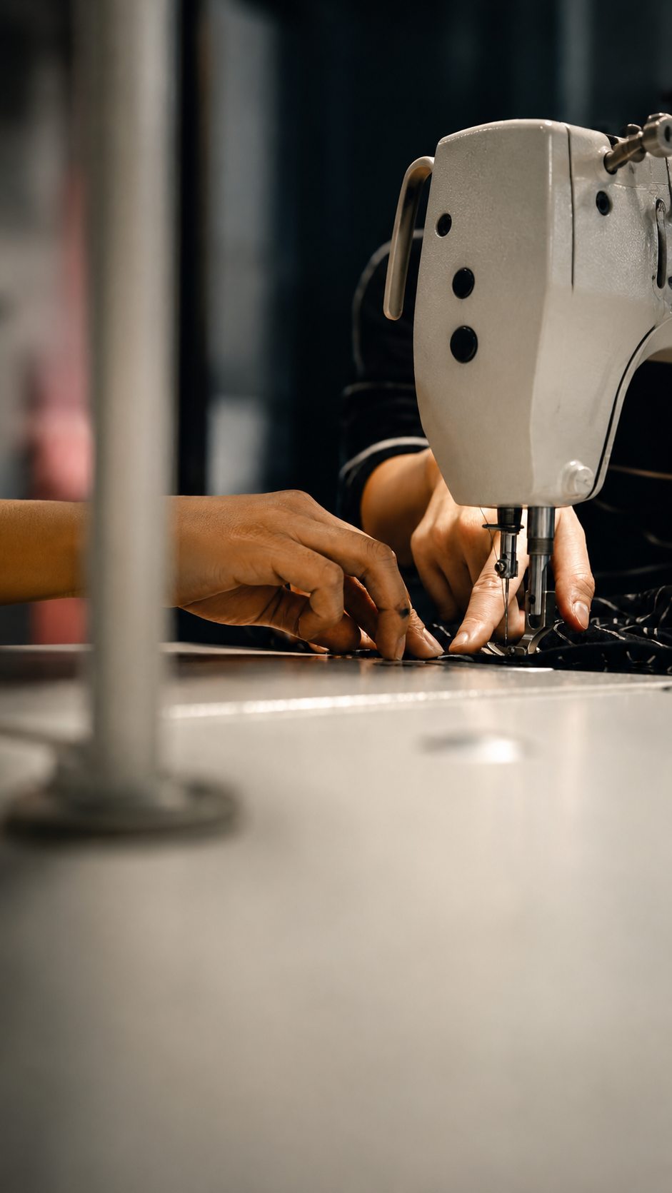 Two hands sewing a piece of clothing