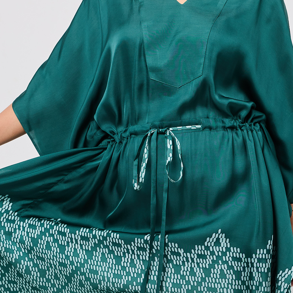 Green dress with a patterned hem on a plain background