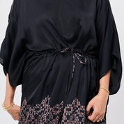 Black dress with patterned trim on a white background