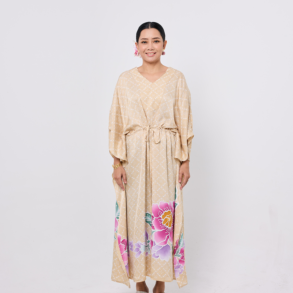 Woman wearing a beige dress with floral patterns on a white background