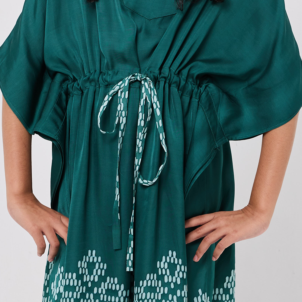 Green dress with a patterned tie on a plain background