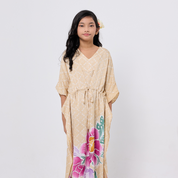 Woman wearing a beige dress with floral designs on a white background