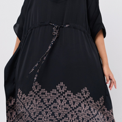Black dress with patterned hem on a white background