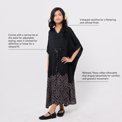 Woman wearing a black dress with a V-shaped neckline and floral details on a white background