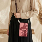 Person holding a pink patterned bag with a blurred background