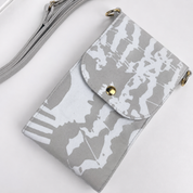 A gray and white abstract patterned crossbody phone bag with a gold snap button and gold-tone hardware, shown on a clean white background.