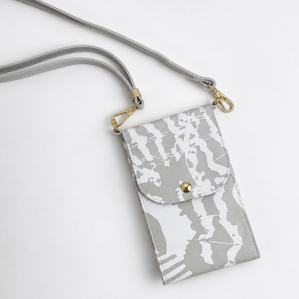 A gray and white abstract patterned crossbody phone pouch with a matching gray strap and gold-tone hardware, shown on a clean white background.
