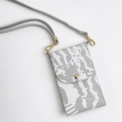A gray and white abstract patterned crossbody phone pouch with a matching gray strap and gold-tone hardware, shown on a clean white background.