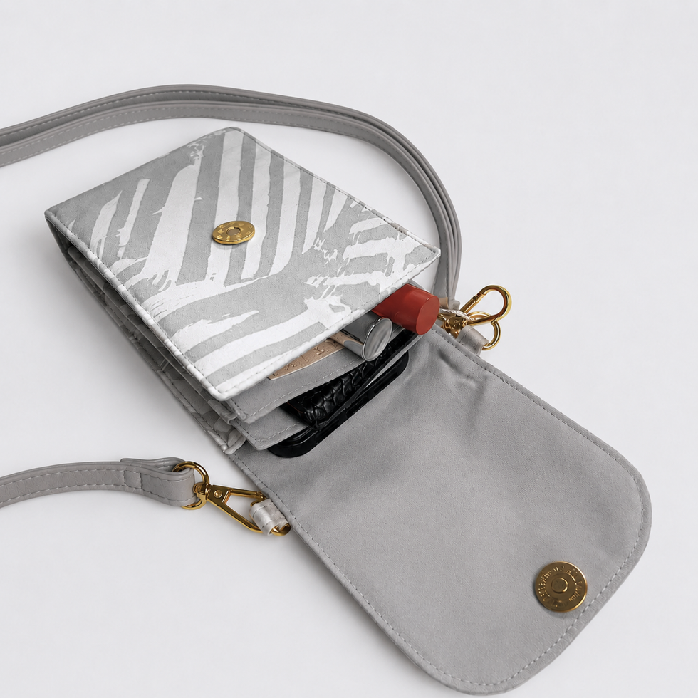 A light gray crossbody wallet with a zebra-printed flap and gold-tone hardware, shown open with its strap draped around it on a white background.