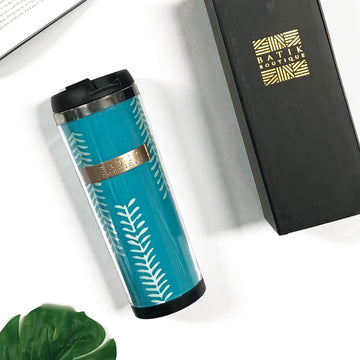 a lifestyle photo of a tumbler made of batik in the pattern mint arrow against a neutral background