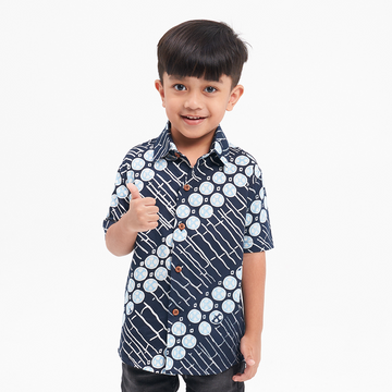 a boy posing in front of a white background in a batik shirt in the pattern navy buluh