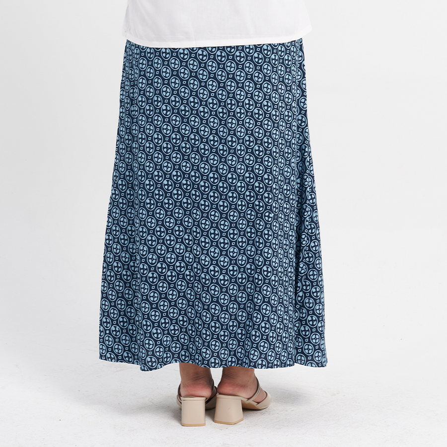 a female model standing against a white background with a batik skirt in the pattern navy lemang