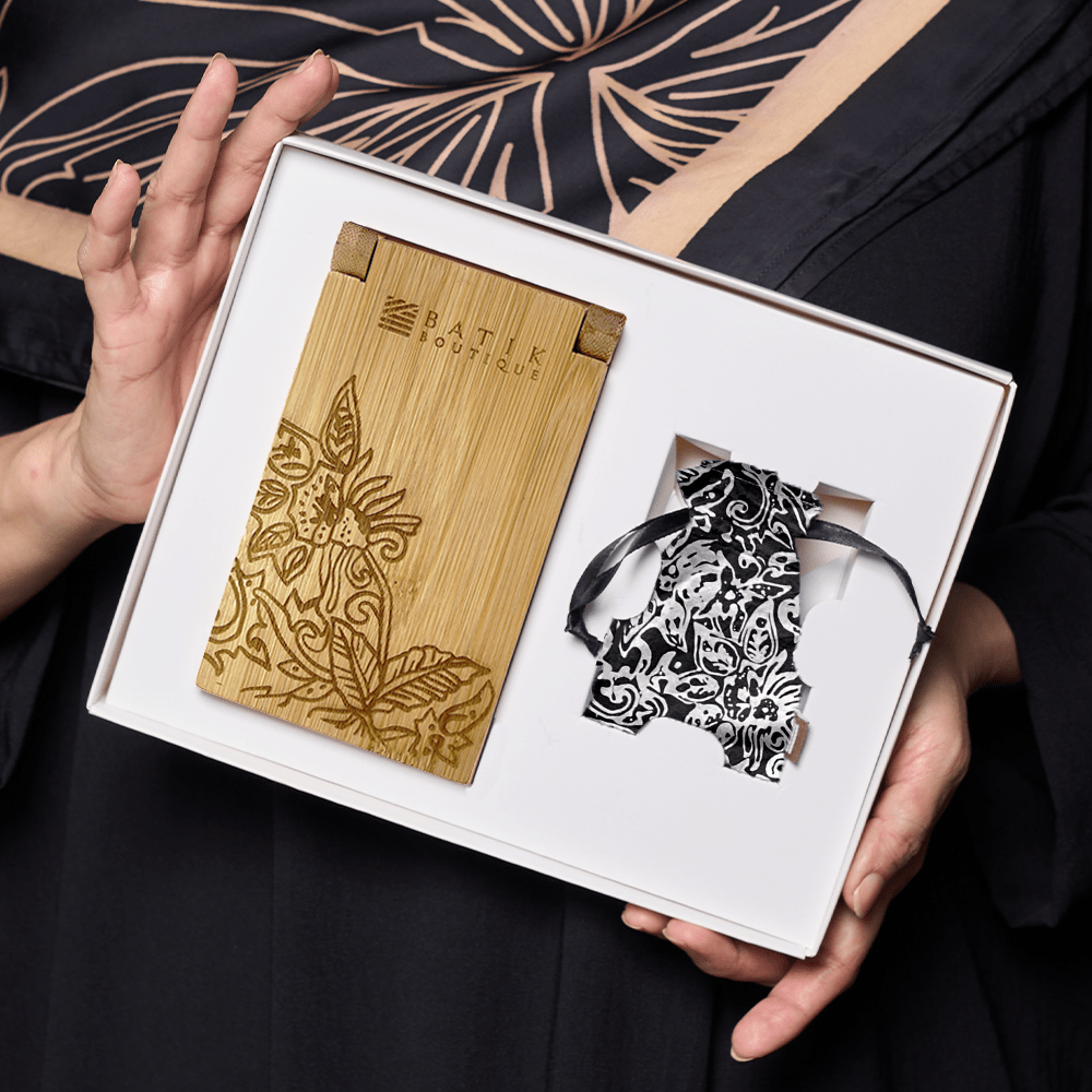 a woman holding a set of congkak with an authetic batik pouch in the pattern black floret