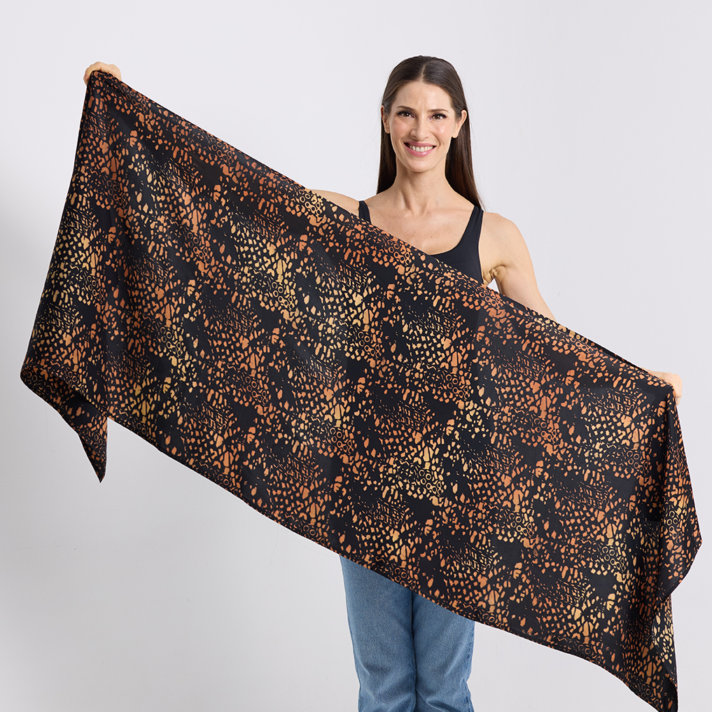 Woman holding a large black and leopard print scarf against a white background