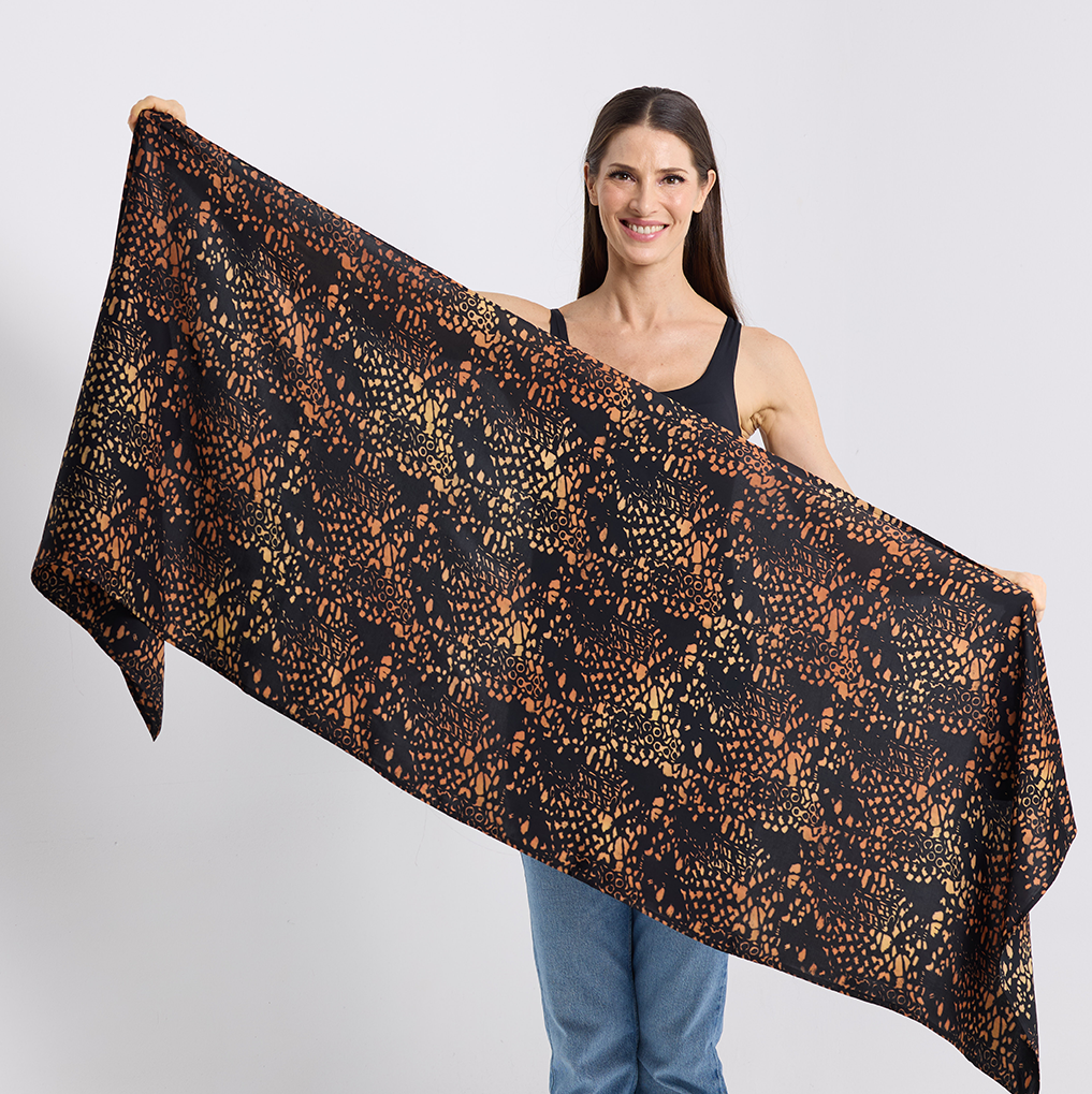 Woman holding a large black and leopard print scarf against a white background