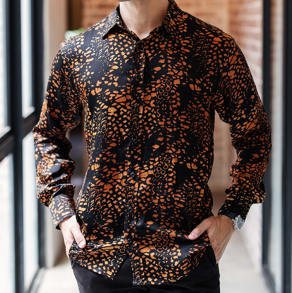 Close-up of Batik Boutique’s Black Leopard Batik Silk Shirt showing intricate hand-blocked motifs and fine silk texture in rich amber and black tones