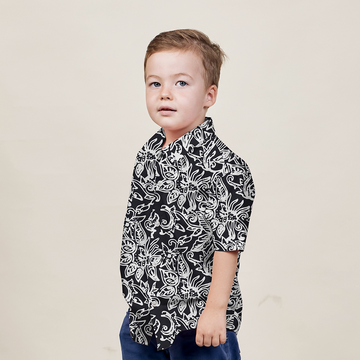 a young model posing in a black batik shirt in the pattern black floret against a white background