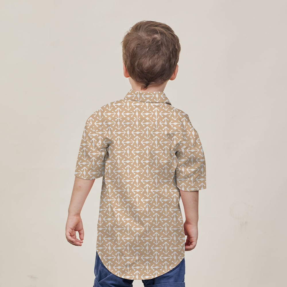 a boy with his back turned away from the camera to showcase the details on the back of the batik shirt in the pattern latte kompas against a white background