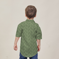 a young boy facing away from the camera to showcase the details on the back of a batik shirt in the pattern olive bintang