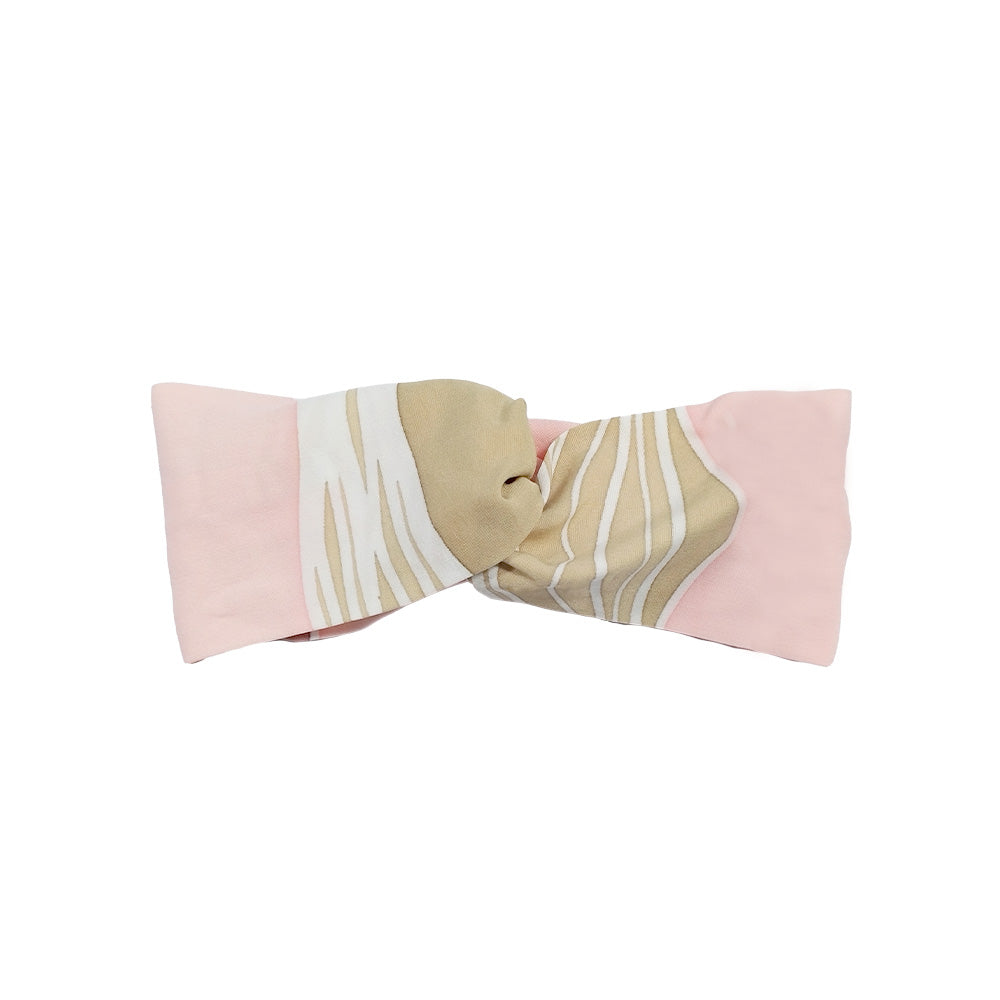 a whitebox photo of a headband in the pattern dawn bukit against a neutral background