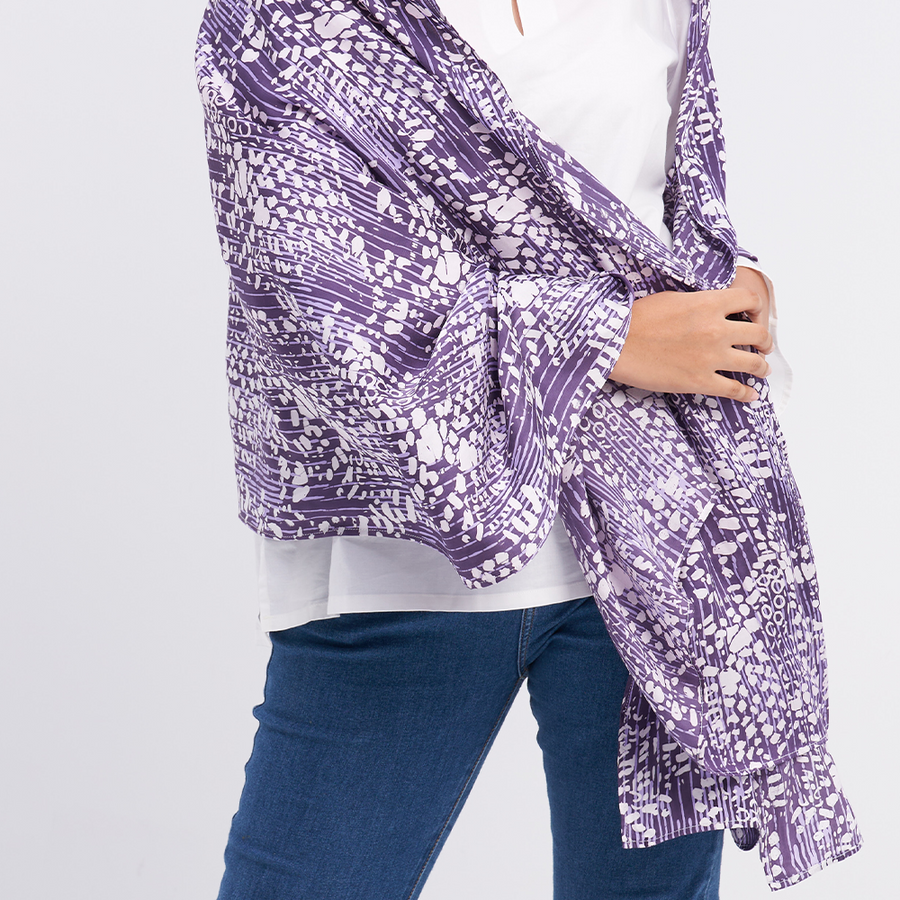 a closeup shot of a batik scarf in the pattern purple bintik against a neutral background