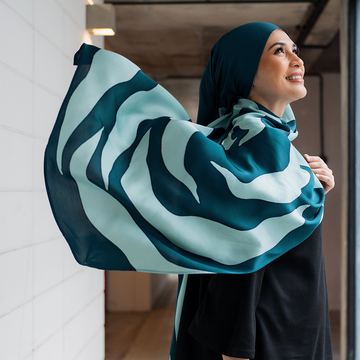 a muslim woman model posing with a batik scarf in a lifestyle photo wearing teal rose
