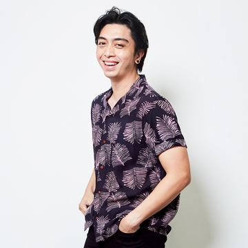 a male model posing in front of a white background in a jet sawit batik shirt