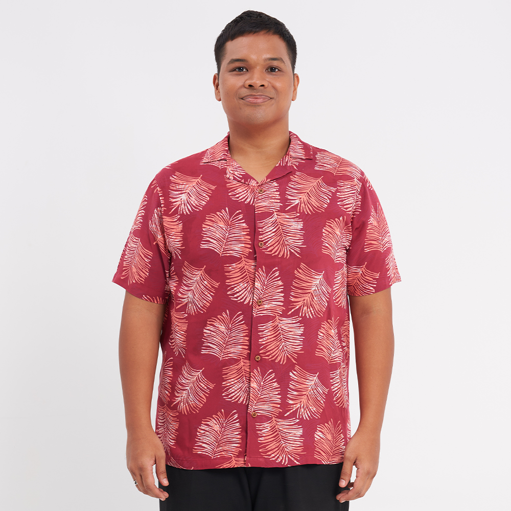 a male model standing in front of a white background to showcase the authentic batik shirt in the pattern crimson sawit