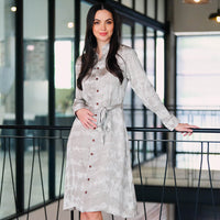 In a stylish lifestyle photo, a woman strikes a pose while wearing a Shibori Long Shirt Dress adorned in the vibrant Mangosteen pattern, showcasing a perfect blend of fashion and elegance