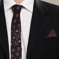 A man wearing tie and pocket square set in brown alur