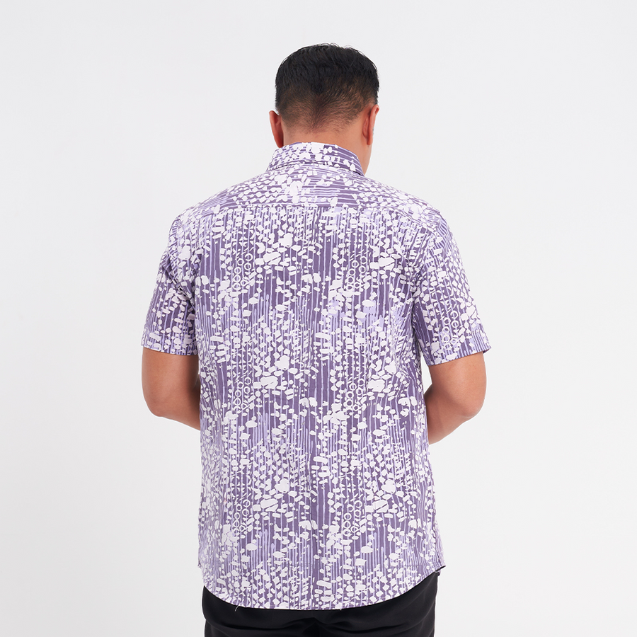 a male model facing away from the camera to showcase the details on the back of the batik shirt in the pattern lavender bintik