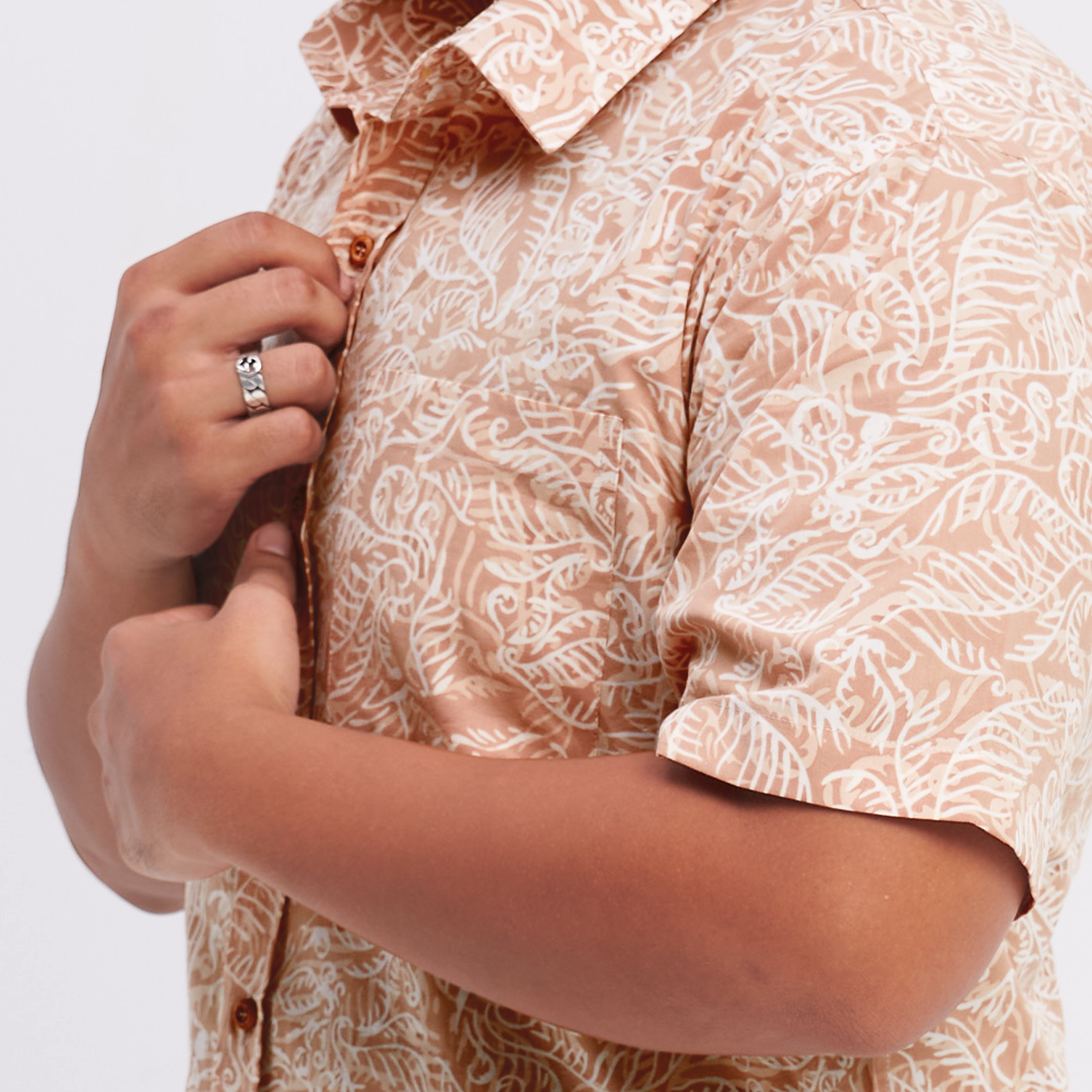 A closeup photo showing batik shirt in tan nautical fern pattern