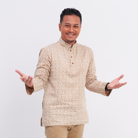 a male model posing welcomingly in a batik kurta in the pattern latte kompas against a white background