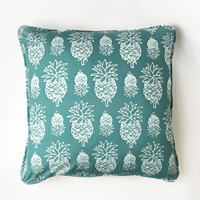 a turquoise pineapple in a white box photo showcasing the details in the front of the pillow