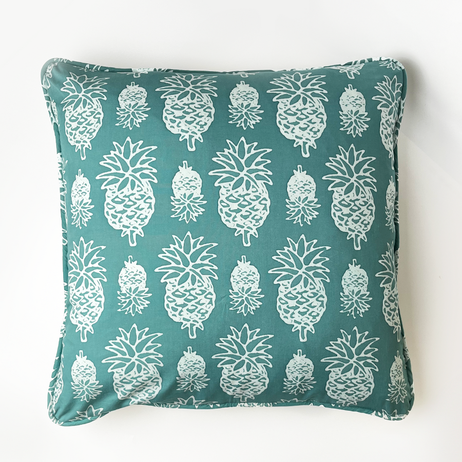 a turquoise pineapple in a white box photo showcasing the details in the front of the pillow