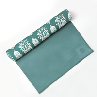 a rolled up batik table runner against neutral background in the pattern turquoise pineapple